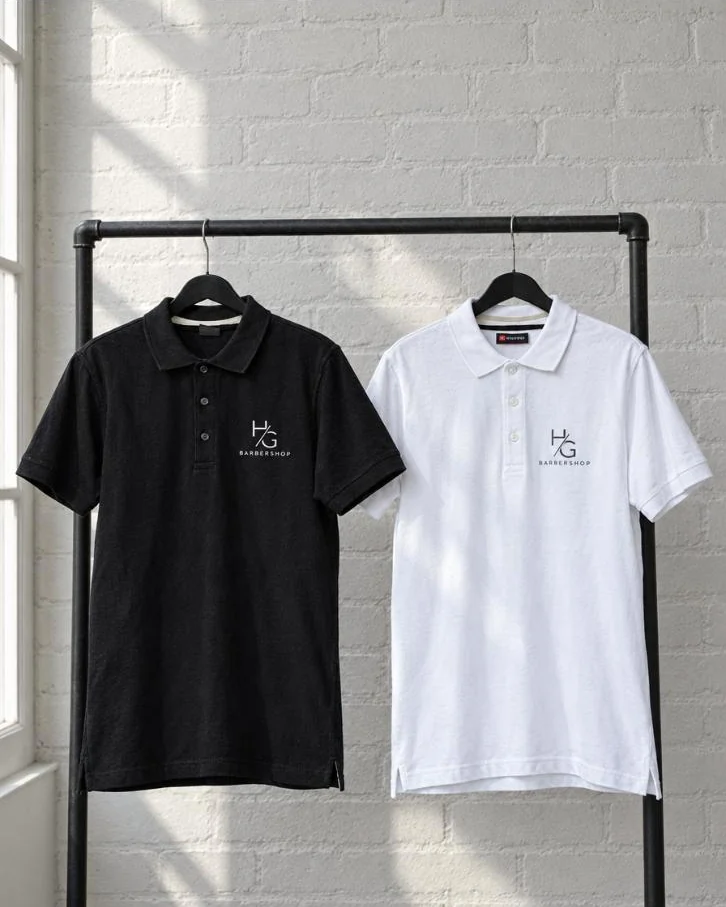 Zwarte en witte polo met logo van Barbershop HG